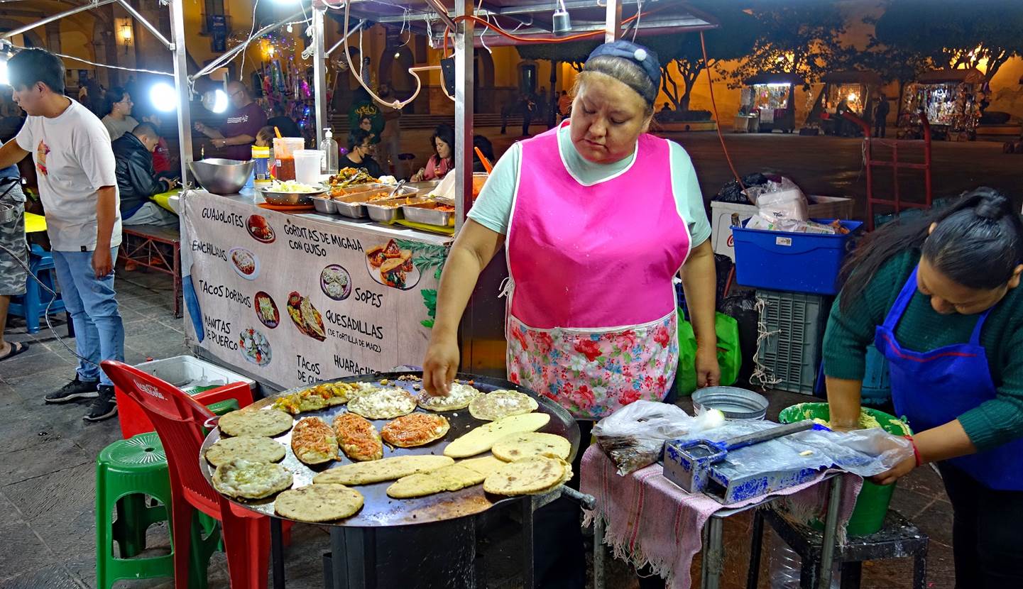 A person selling food at an outdoor market

Description automatically generated with medium confidence