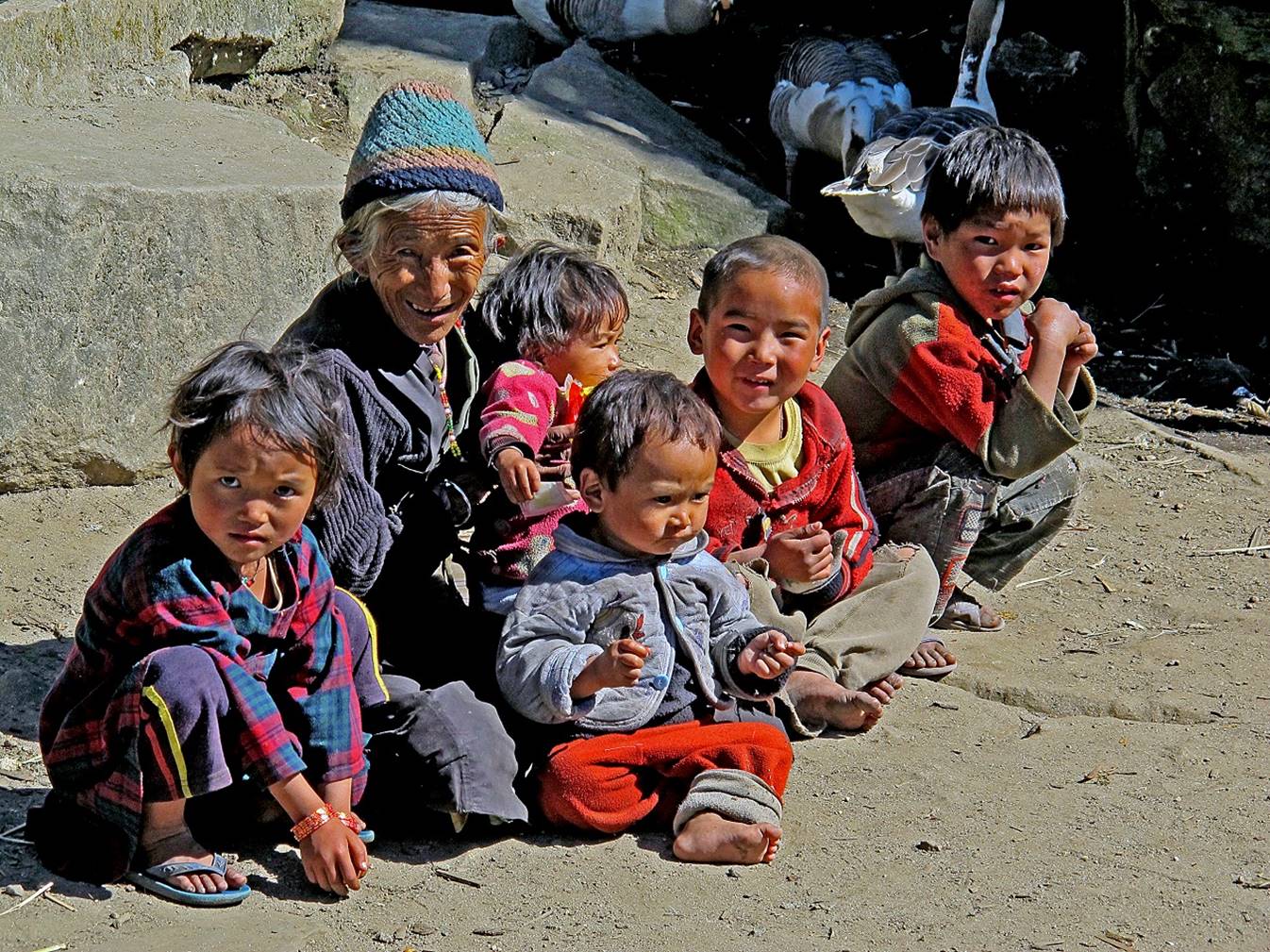 A group of children sitting on the ground

Description automatically generated