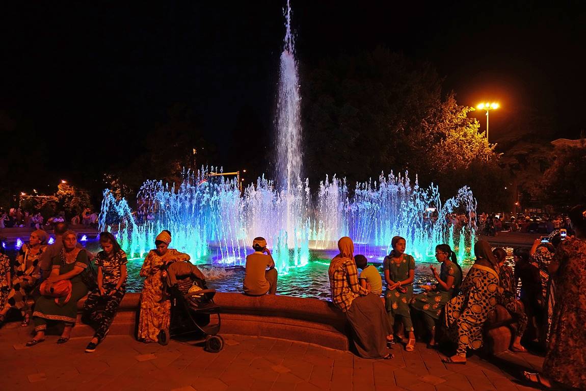 A group of people sitting in front of a water fountain

Description automatically generated