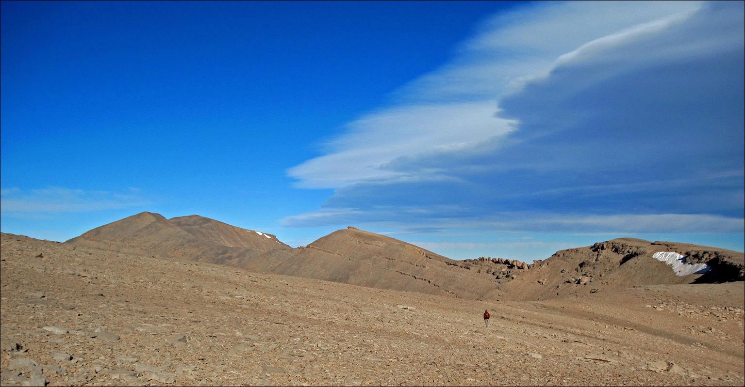 A large sandy desert with mountains and blue sky

Description automatically generated with medium confidence