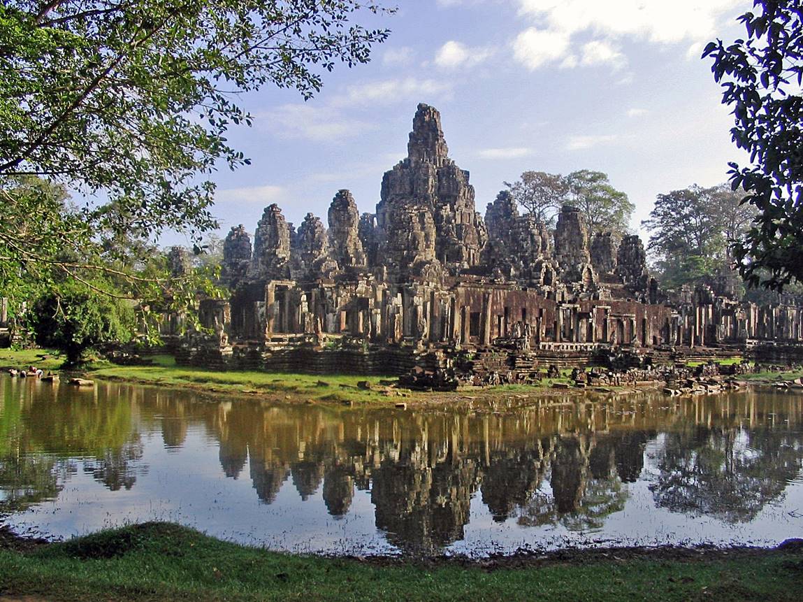 A large stone building with a body of water with Angkor Wat in the background

Description automatically generated