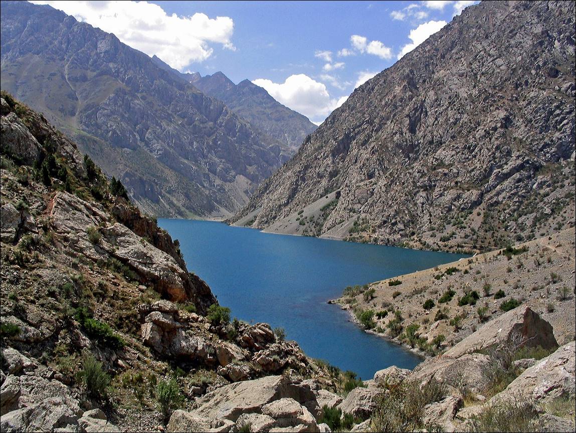 A blue lake surrounded by mountains with Hells Canyon in the background

Description automatically generated
