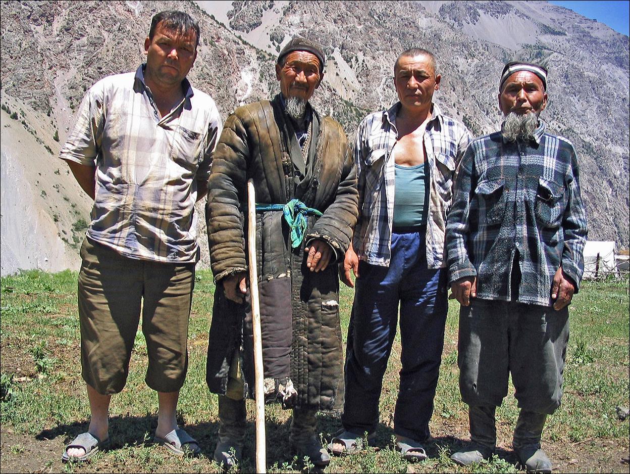 A group of men standing in a field

Description automatically generated