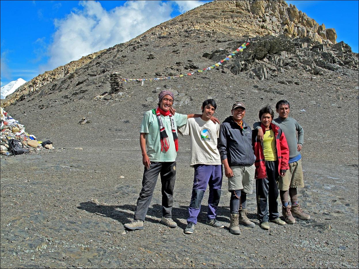 A group of people standing in a rocky area

Description automatically generated