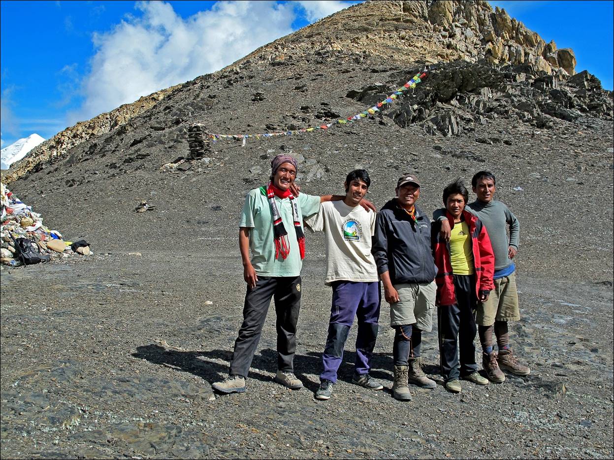A group of people standing in a rocky area

Description automatically generated