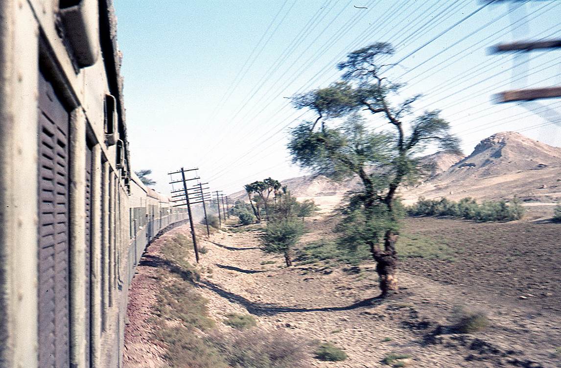 A train going through the desert

Description automatically generated