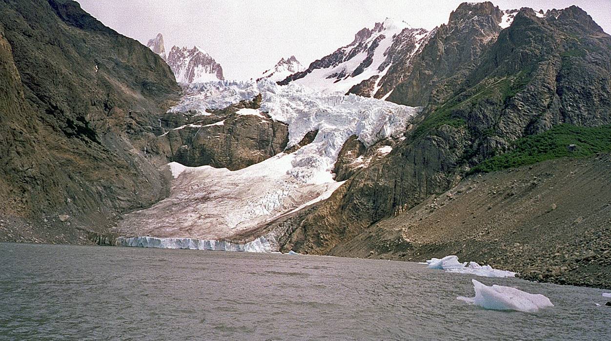 A glacier next to a body of water

Description automatically generated