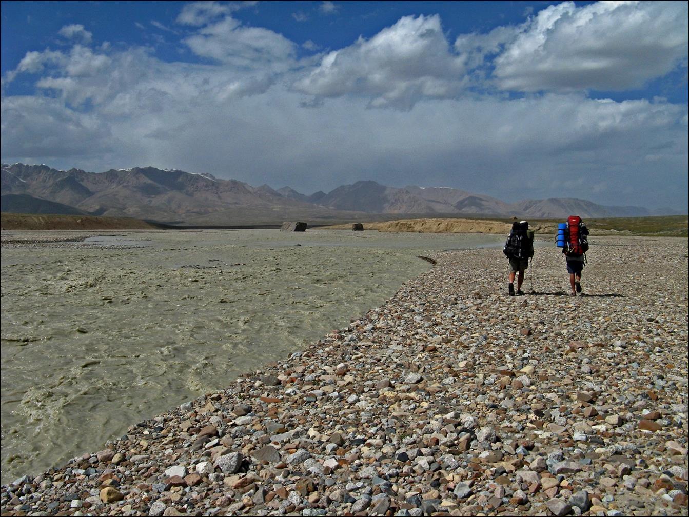 A group of people walking on a rocky beach

Description automatically generated