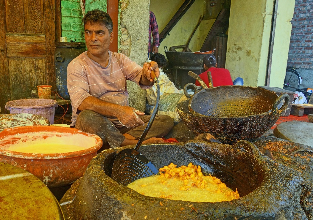 A person cooking food in a kitchen

Description automatically generated with medium confidence