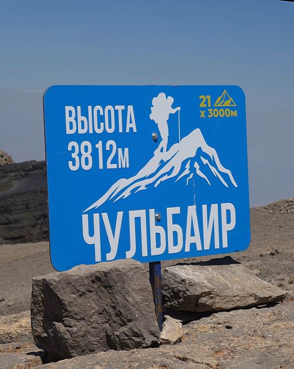 A blue sign with white text and a mountain on the top

Description automatically generated