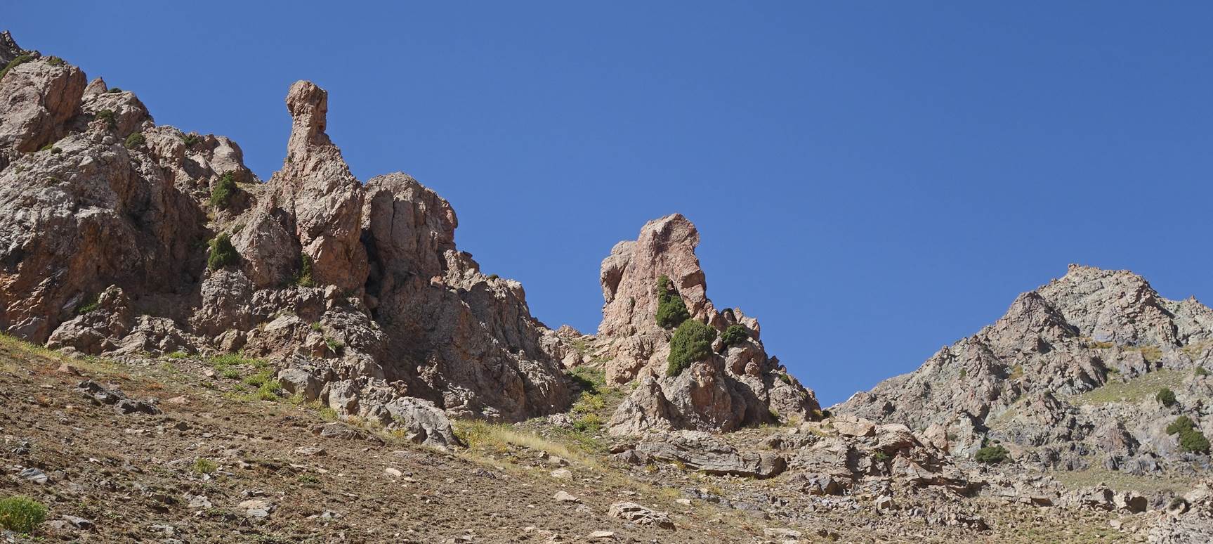 A rocky mountain with blue sky

Description automatically generated